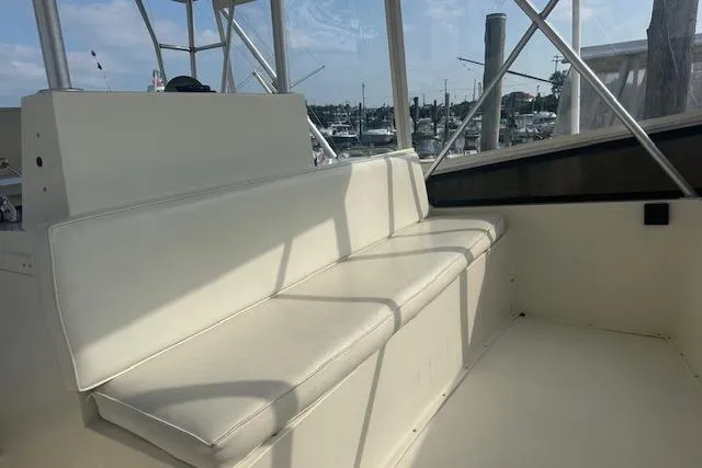 Arete Yacht Photos Pics 1988 Viking 45 Convertible boat interior with white seating and marina view.