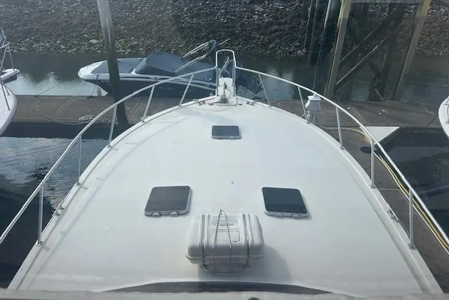 Arete Yacht Photos Pics 1988 Viking 45 Convertible boat docked, view from the bow, with surrounding watercraft.