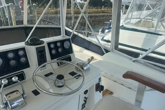 Arete Yacht Photos Pics 1988 Viking 45 Convertible yacht helm with steering wheel and control panel.