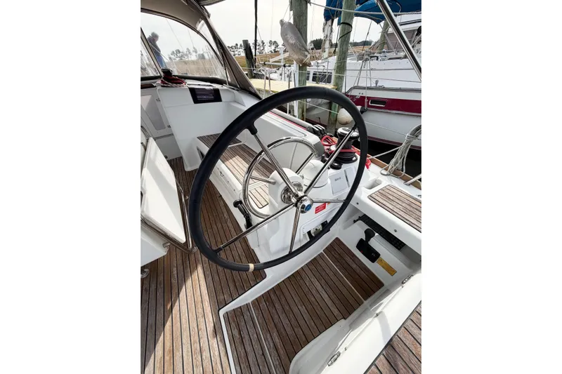 Take Five Yacht Photos Pics Steering wheel of 2013 Jeanneau Sun Odyssey 409 sailboat with wooden deck.