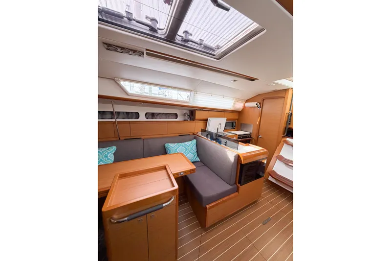Take Five Yacht Photos Pics Interior of 2013 Jeanneau Sun Odyssey 409 sailboat with modern wood finish and seating area.