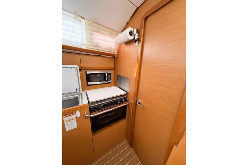 Take Five Yacht Photos Pics Interior of 2013 Jeanneau Sun Odyssey 409 yacht kitchen with wood finish and modern appliances.
