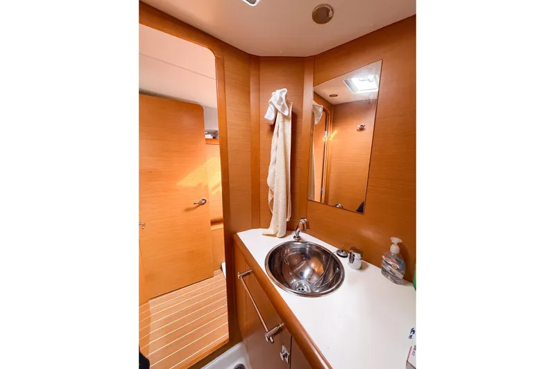 Take Five Yacht Photos Pics Bathroom interior of 2013 Jeanneau Sun Odyssey 409 yacht with wooden finish and stainless steel sink.