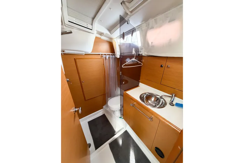 Take Five Yacht Photos Pics Bathroom interior of 2013 Jeanneau Sun Odyssey 409 yacht, featuring wooden cabinetry and modern fixtures.