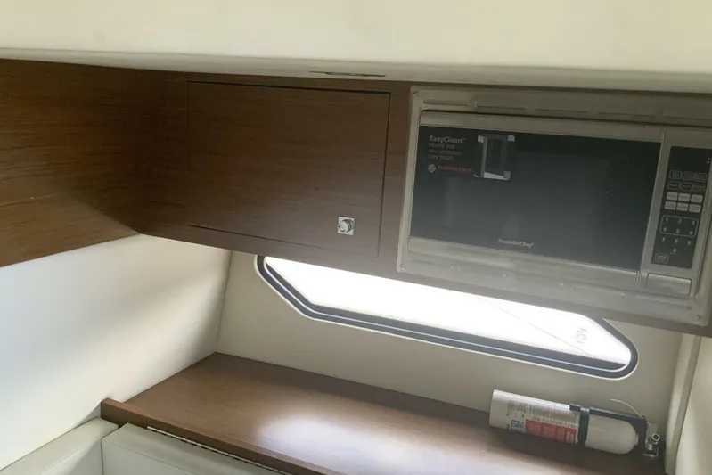  Yacht Photos Pics 2015 Cruisers Sport Series 328 BR interior with microwave and wooden cabinetry.