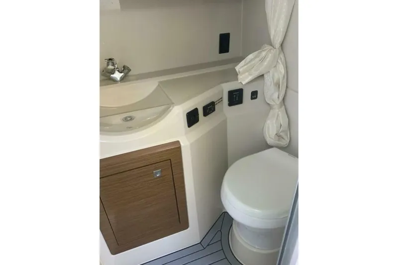  Yacht Photos Pics 2015 Cruisers Sport Series 328 BR boat bathroom with sink, toilet, and storage cabinet.