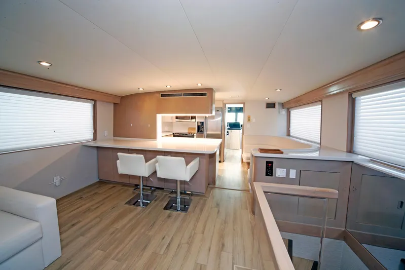 Final Kiwi Yacht Photos Pics Luxurious interior of 1995 Hatteras 74 Cockpit Motor Yacht with modern kitchen and seating.