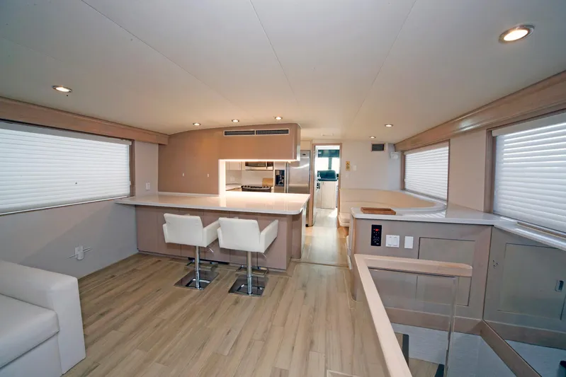 Final Kiwi Yacht Photos Pics Luxurious interior of 1995 Hatteras 74 Cockpit Motor Yacht with modern kitchen and seating.