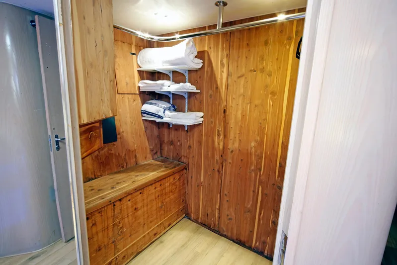 Final Kiwi Yacht Photos Pics Wood-paneled storage area with shelves and bench on 1995 Hatteras 74 Cockpit Motor Yacht.