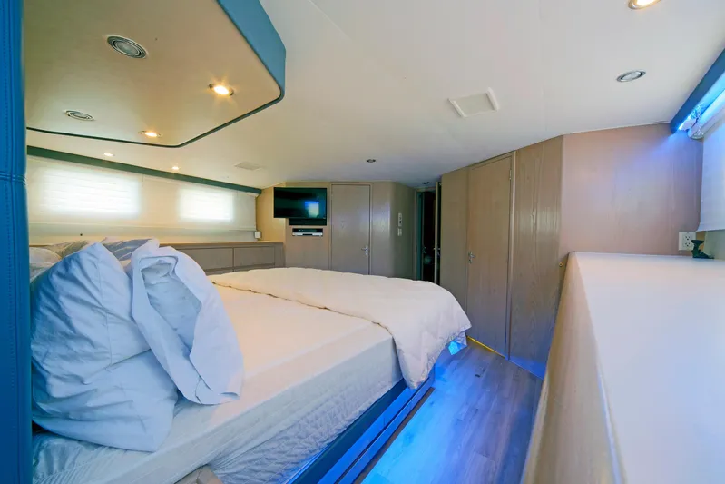 Final Kiwi Yacht Photos Pics Luxurious bedroom interior of 1995 Hatteras 74 Cockpit Motor Yacht with modern amenities.