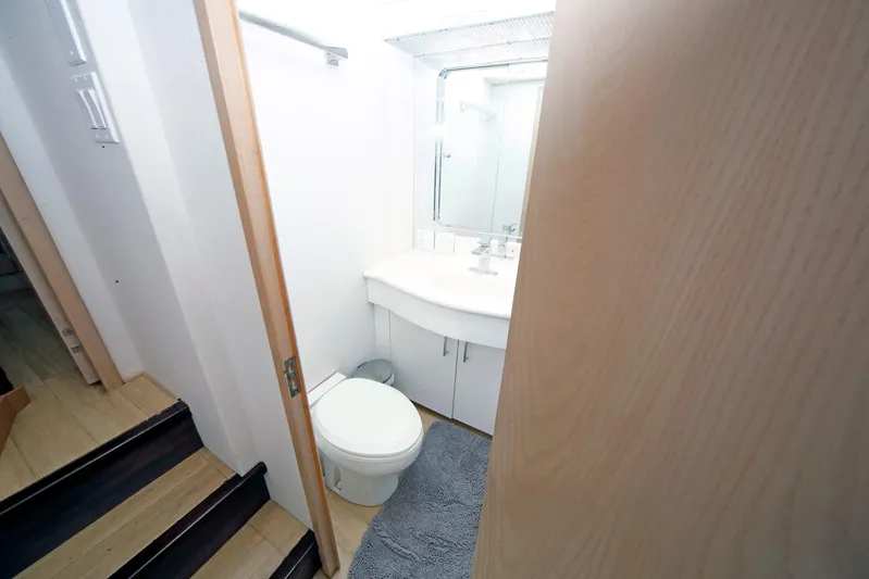 Final Kiwi Yacht Photos Pics Bathroom interior of 1995 Hatteras 74 Cockpit Motor Yacht, featuring modern fixtures and wooden accents.