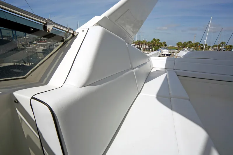 Final Kiwi Yacht Photos Pics 1995 Hatteras 74 Cockpit Motor Yacht, white seating area, marina background.