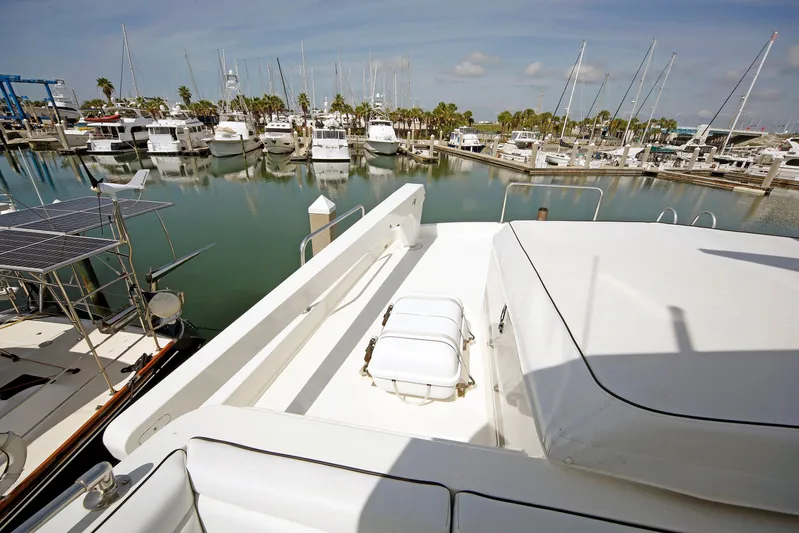 Final Kiwi Yacht Photos Pics 1995 Hatteras 74 Cockpit Motor Yacht docked in a marina with other boats.
