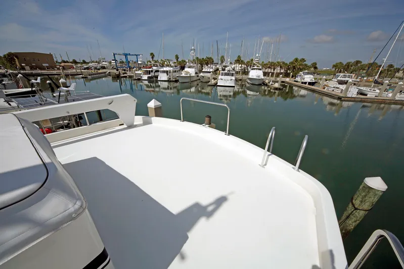 Final Kiwi Yacht Photos Pics 1995 Hatteras 74 Cockpit Motor Yacht docked in a marina with calm waters.
