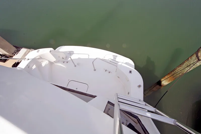 Final Kiwi Yacht Photos Pics 1995 Hatteras 74 Cockpit Motor Yacht stern view with dock and water.