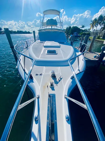  Yacht Photos Pics 1999 Tiara Yachts 43 Open docked, sunny day, clear blue sky, calm water.