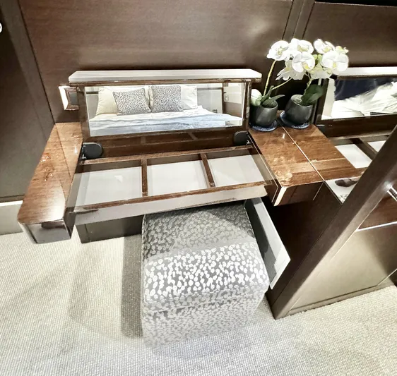 Journey Yacht Photos Pics Luxurious vanity area on 2019 Sunseeker 76 Yacht with mirror, stool, and decorative flowers.