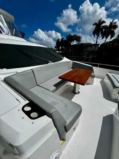 Journey Yacht Photos Pics 2019 Sunseeker 76 Yacht deck with seating and table under blue sky.