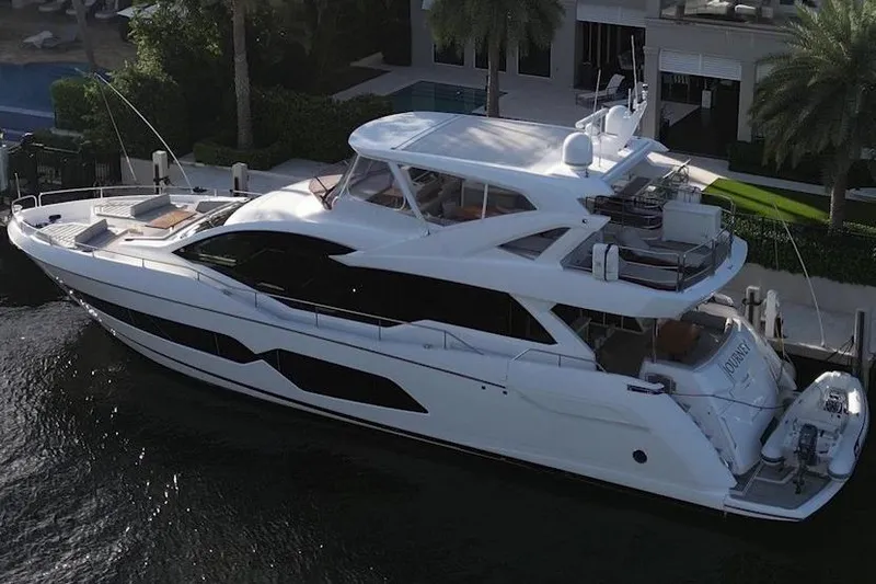 Journey Yacht Photos Pics 2019 Sunseeker 76 Yacht docked near a luxurious waterfront property.