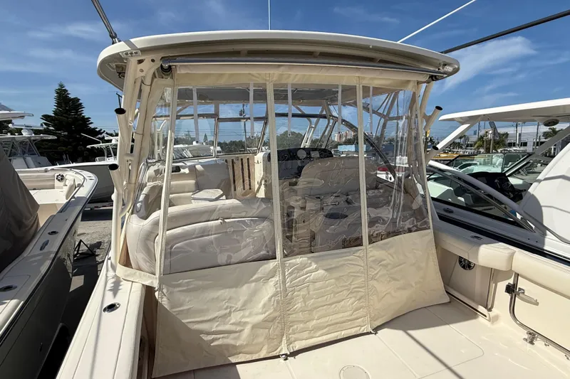 335-514 Brokerage Ron Yacht Photos Pics 2023 Grady-White Freedom 335 boat with enclosed cockpit, docked under clear blue sky.