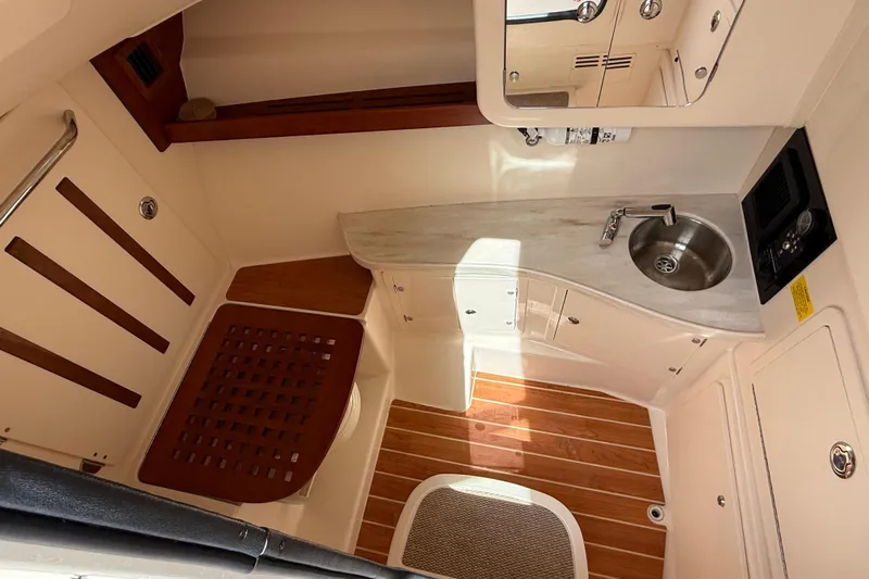 335-514 Brokerage Ron Yacht Photos Pics 2023 Grady-White Freedom 335 boat interior with sink and wooden flooring.