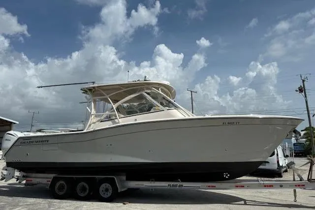 335-514 Brokerage Ron Yacht Photos Pics 2023 Grady-White Freedom 335 boat on trailer under cloudy sky.