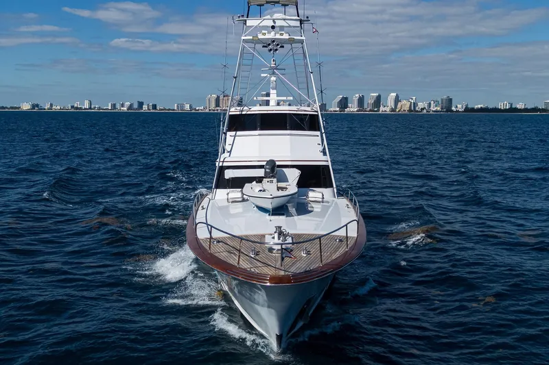  Yacht Photos Pics 1985 Feadship Yacht Fisherman cruising on open water with city skyline backdrop.