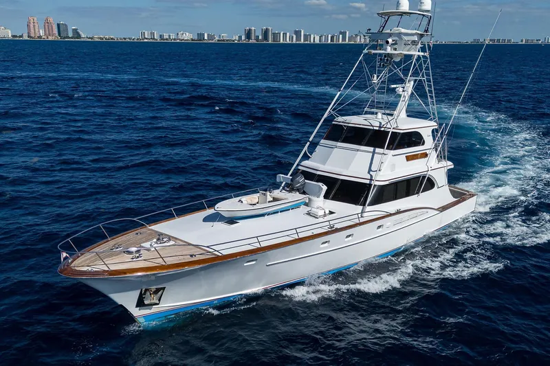  Yacht Photos Pics 1985 Feadship Yacht Fisherman cruising on open sea with city skyline in background.