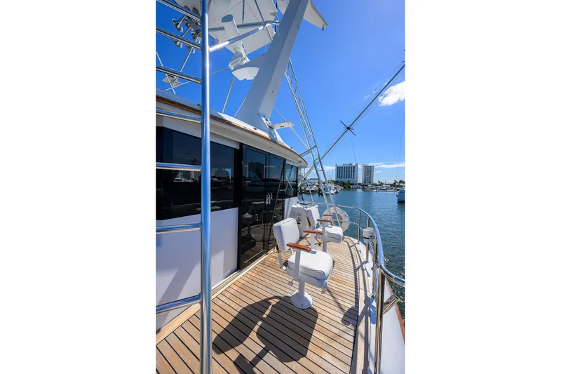  Yacht Photos Pics 1985 Feadship Yacht Fisherman deck with chairs, overlooking marina under clear blue sky.