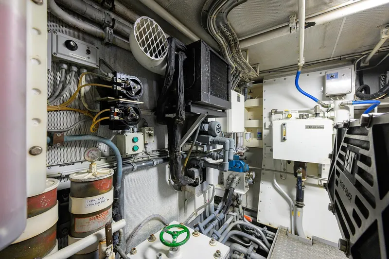  Yacht Photos Pics Engine room of a 1985 Feadship Yacht Fisherman, showcasing complex machinery and piping.