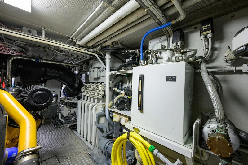  Yacht Photos Pics Engine room of a 1985 Feadship Yacht Fisherman, showcasing complex machinery and piping.