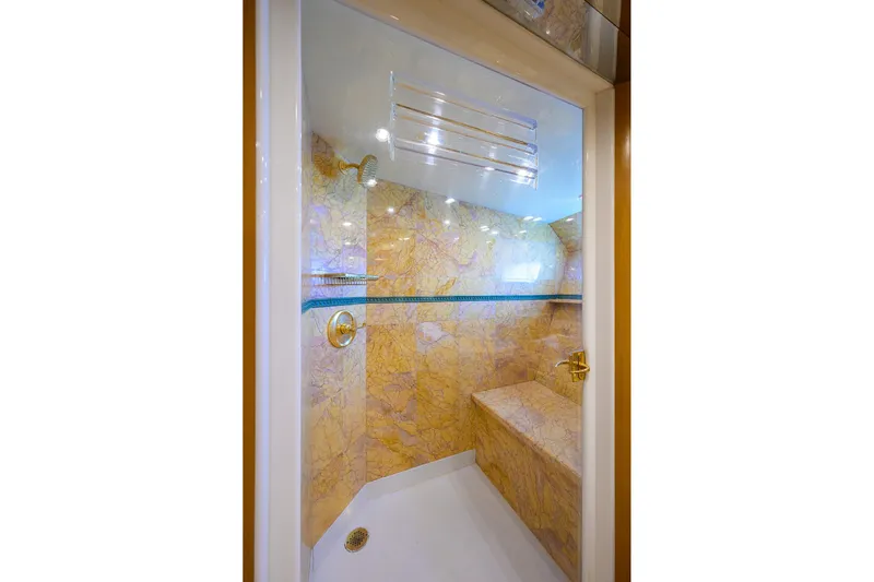  Yacht Photos Pics Luxurious marble shower interior on 1985 Feadship Yacht Fisherman, featuring gold fixtures and seating.