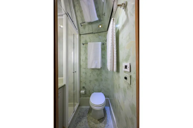  Yacht Photos Pics Compact bathroom on 1985 Feadship Yacht Fisherman with modern fixtures and green walls.