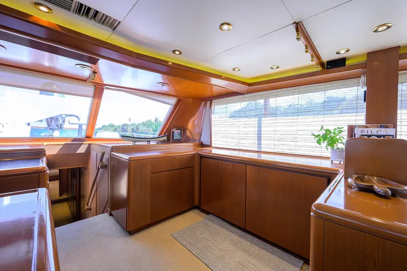  Yacht Photos Pics Luxurious 1985 Feadship Yacht Fisherman interior with wooden cabinetry and large windows.