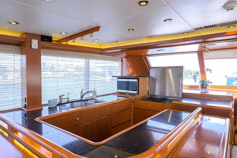  Yacht Photos Pics Luxurious kitchen interior of 1985 Feadship Yacht Fisherman with modern amenities and wood finishes.