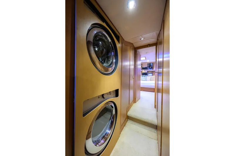  Yacht Photos Pics Laundry area inside 1985 Feadship Yacht Fisherman, featuring stacked washer and dryer.