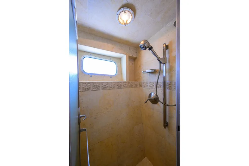  Yacht Photos Pics Shower area in 1985 Feadship Yacht Fisherman, featuring a window and modern fixtures.