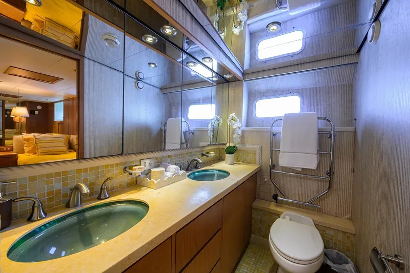  Yacht Photos Pics Luxurious bathroom in 1985 Feadship Yacht Fisherman, featuring elegant fixtures and mirrored walls.