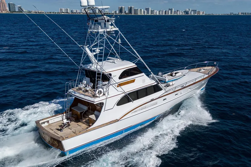  Yacht Photos Pics 1985 Feadship Yacht Fisherman cruising on open sea with city skyline in background.