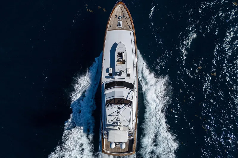  Yacht Photos Pics Aerial view of 1985 Feadship Yacht Fisherman cruising through deep blue ocean waters.