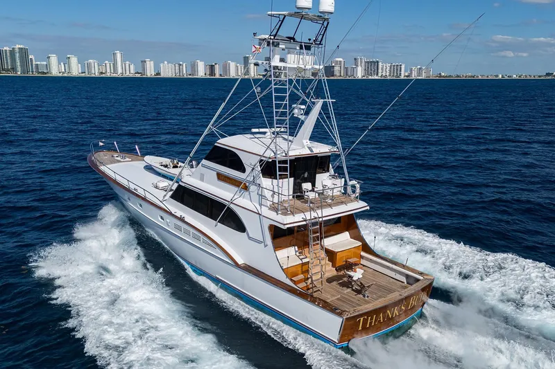  Yacht Photos Pics 1985 Feadship Yacht Fisherman cruising near a city skyline on a sunny day.