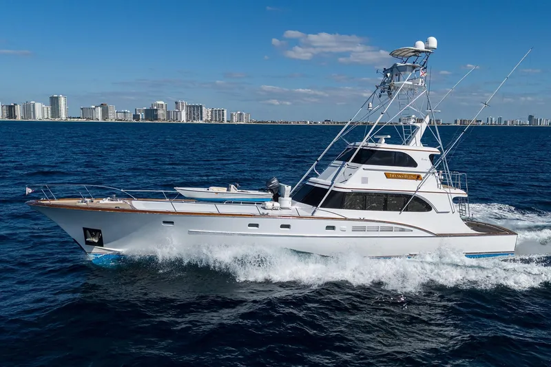  Yacht Photos Pics 1985 Feadship Yacht Fisherman cruising on ocean with city skyline in background.