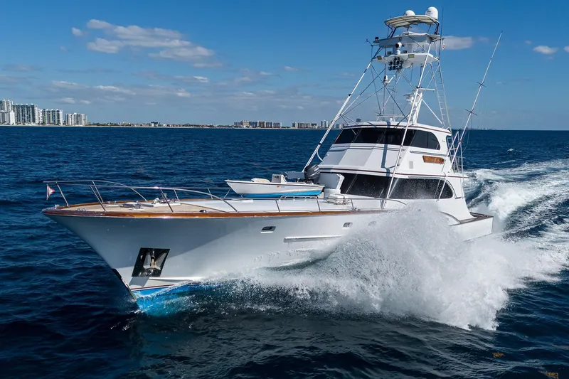  Yacht Photos Pics 1985 Feadship Yacht Fisherman cruising on open sea with city skyline in background.