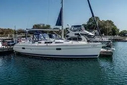 2003 Hunter 356 sailboat docked in a marina, featuring a sleek white hull and blue accents.