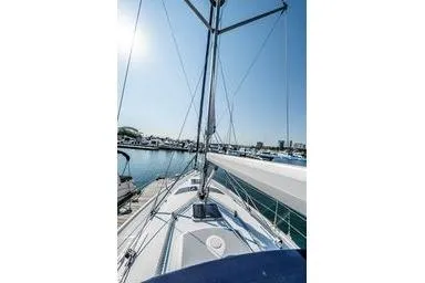 2003 Hunter 356 sailboat deck view at marina under clear sky.