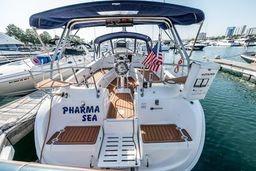 2003 Hunter 356 sailboat docked, featuring "Pharma Sea" name and American flag.