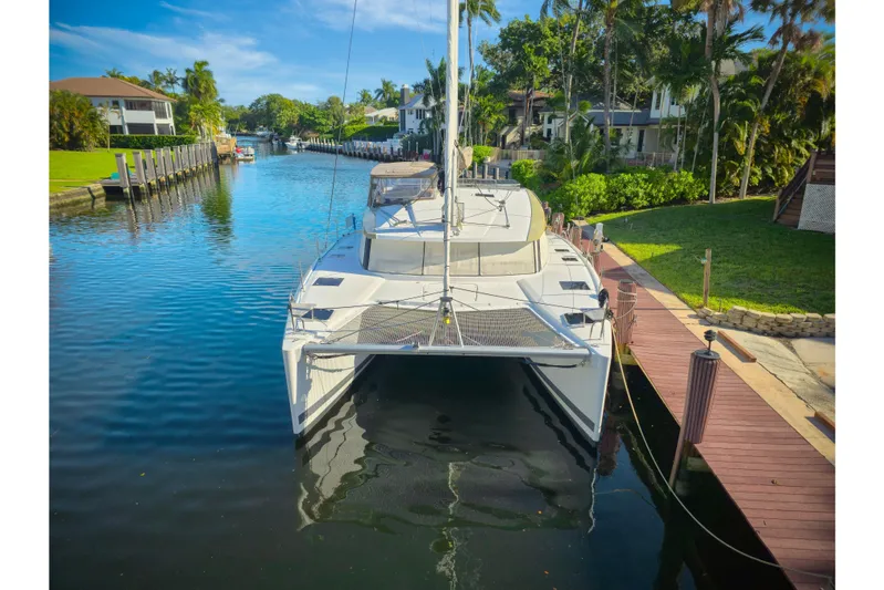 Waterlilly Yacht Photos Pics 2017 Fountaine Pajot Lucia 40 catamaran docked in a scenic canal setting.