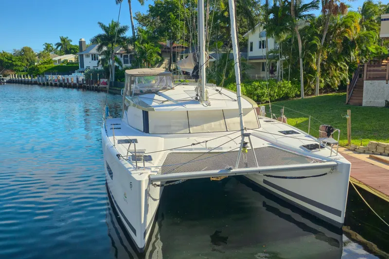 Waterlilly Yacht Photos Pics 2017 Fountaine Pajot Lucia 40 catamaran docked by a scenic waterfront.