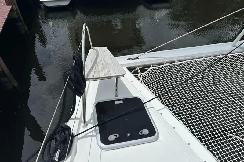 Waterlilly Yacht Photos Pics 2017 Fountaine Pajot Lucia 40 catamaran deck with netting and ropes, docked by water.