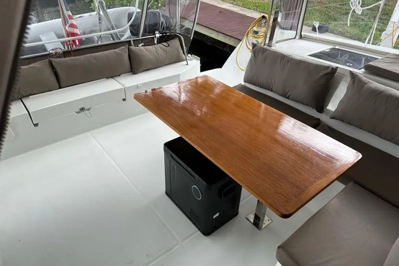 Waterlilly Yacht Photos Pics 2017 Fountaine Pajot Lucia 40 catamaran cockpit with wooden table and cushioned seating.